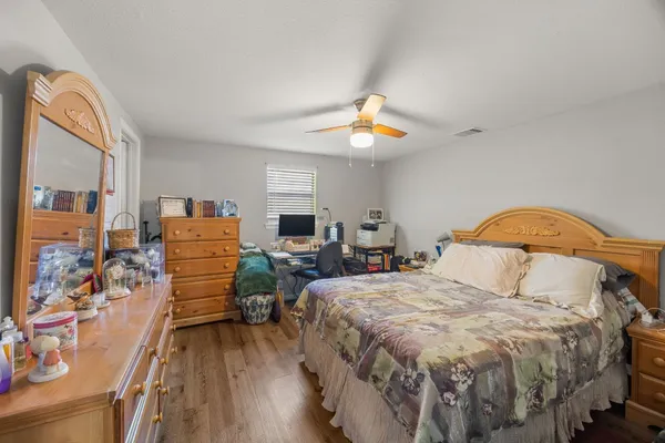 a bedroom with a bed and a wooden floor