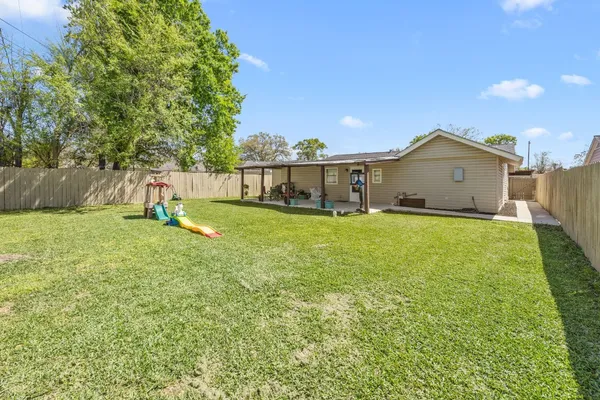 a view of a house with a big yard and a large tree