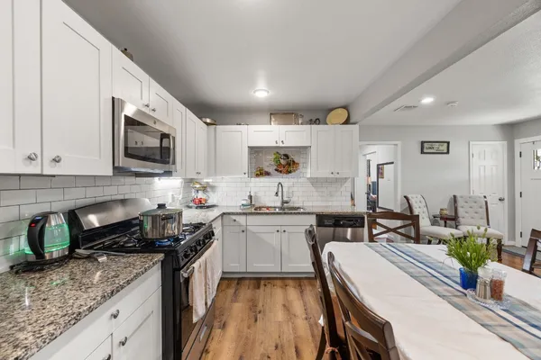 a kitchen with sink stove microwave and cabinets