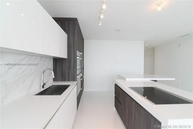 a kitchen with a sink and a stove top oven