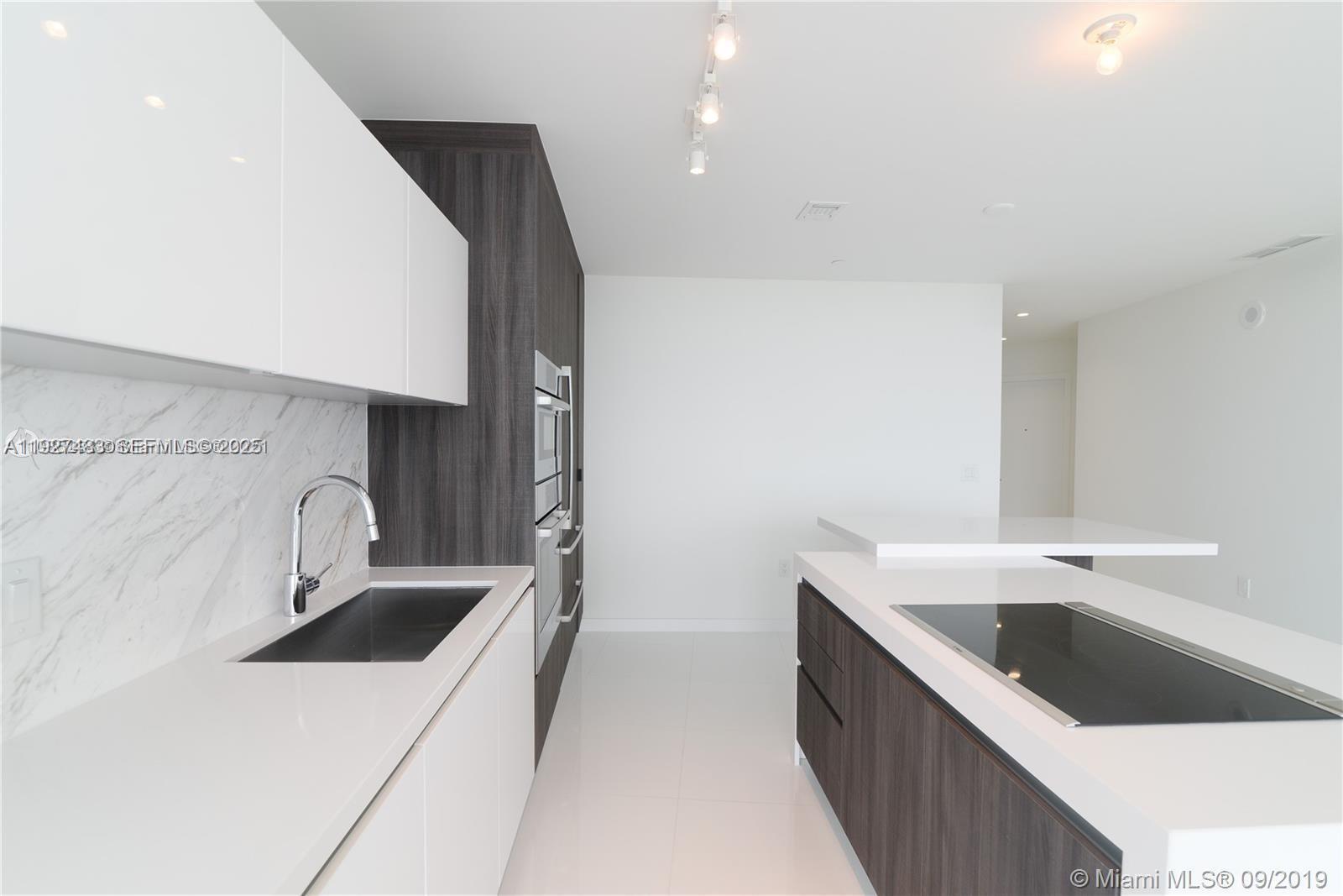 851 Northeast 1st Avenue, Unit 4110 Miami, FL 33132 - Photo 5 of 9 a kitchen with a sink and a stove top oven
