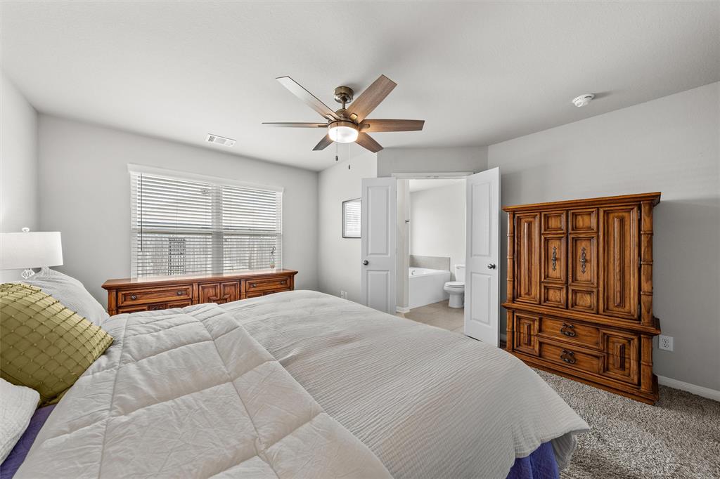 4056 Centerfire Road Waco, TX 76705 - Photo 14 of 27 a bedroom with a large bed dresser and a window
