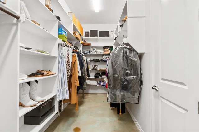 a view of walk in closet with clothes and shoes