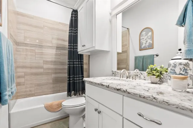 a bathroom with a granite countertop sink toilet and a mirror
