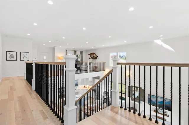 a view of a hallway with wooden floor and windows