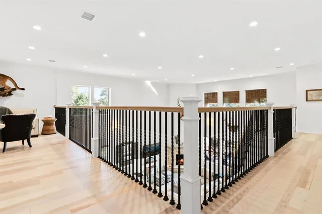 a view of a hallway with wooden floor and windows