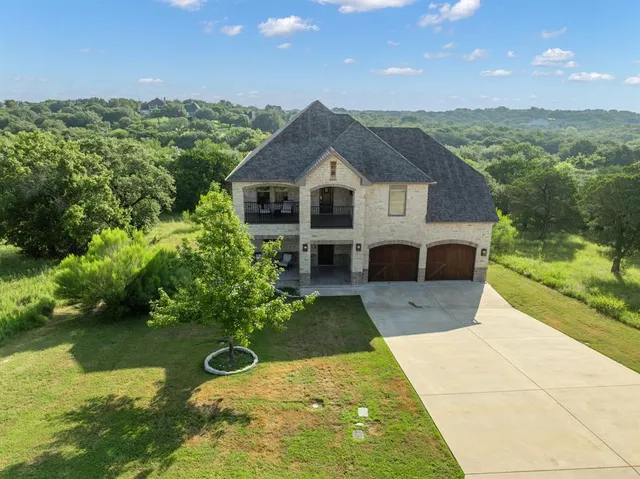 a view of a house with a yard and potted plants