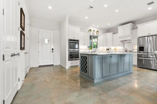 a kitchen with stainless steel appliances kitchen island granite countertop a sink and cabinets