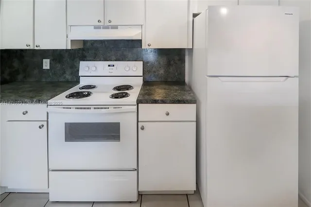 a stove top oven sitting inside of a kitchen