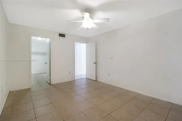 an empty room with fan and natural light