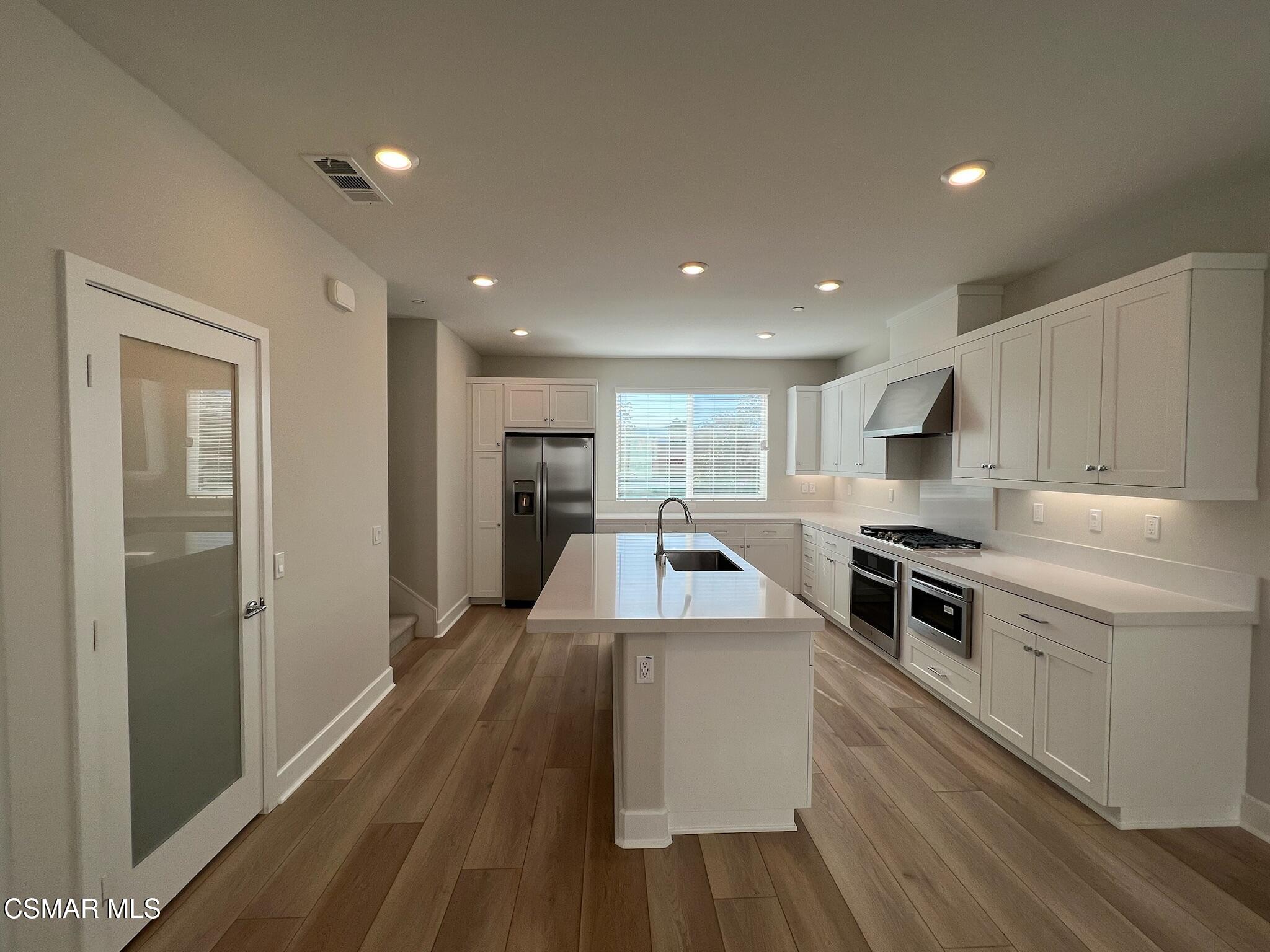 3005 Cochran Street Simi Valley, CA 93065 - Photo 22 of 57 a kitchen with kitchen island a stove a sink and a refrigerator