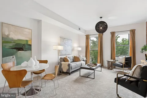 a living room with furniture a large window and a clock