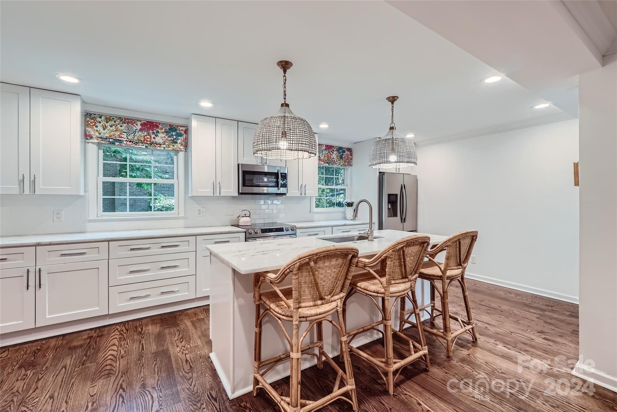 3910 Chevington Road Charlotte, NC 28226 - Photo 11 of 40 a view of a kitchen with kitchen island granite countertop wooden floor cabinets and stainless steel appliances