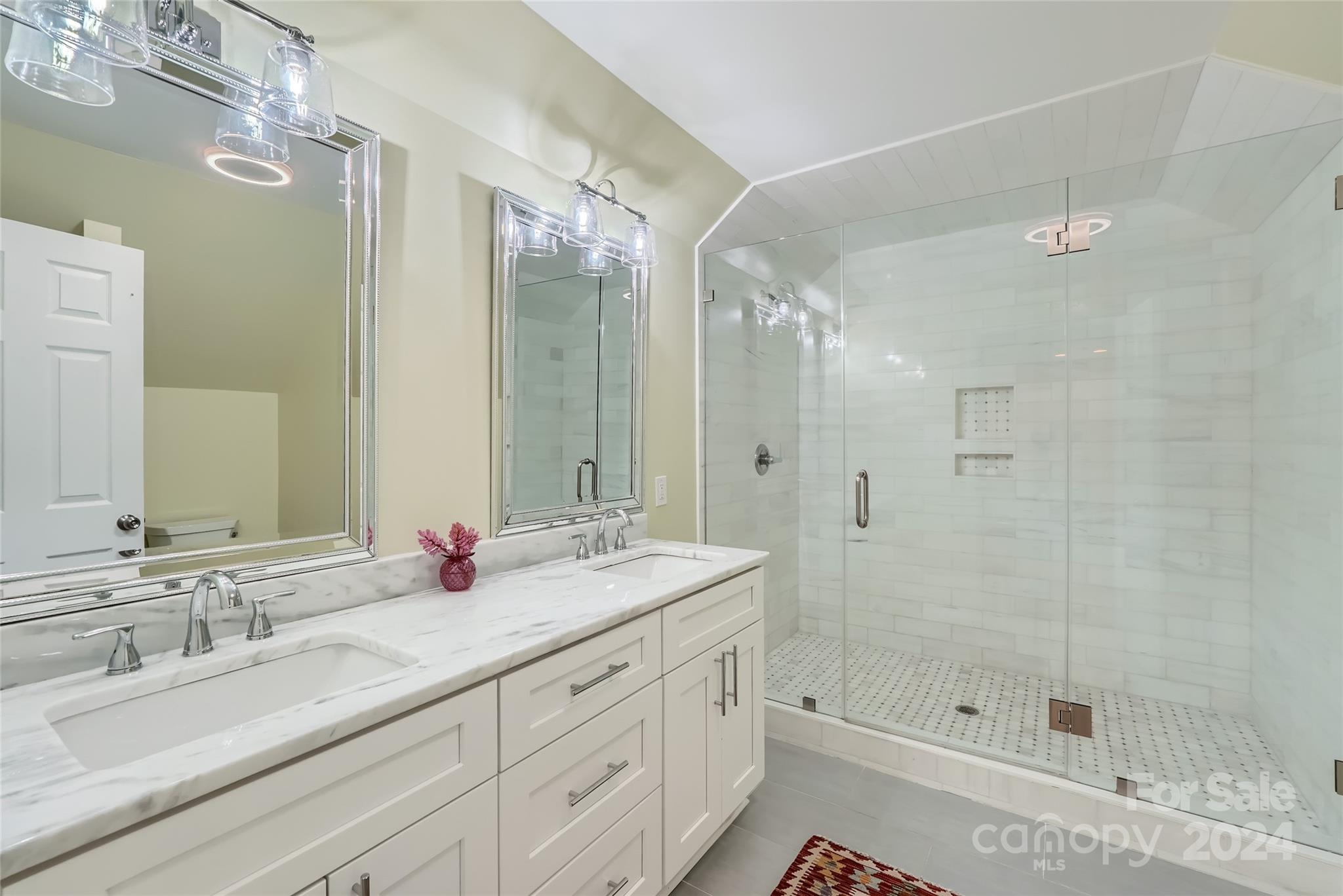 3910 Chevington Road Charlotte, NC 28226 - Photo 31 of 40 a bathroom with a shower tub double vanity and a mirror