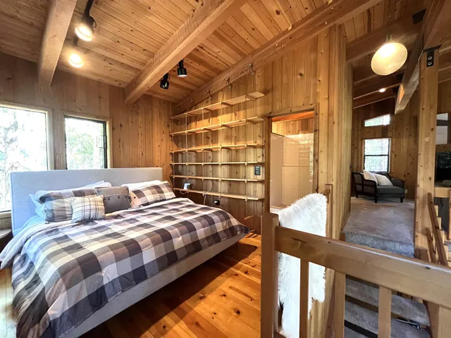 a bedroom with bed and wooden floor