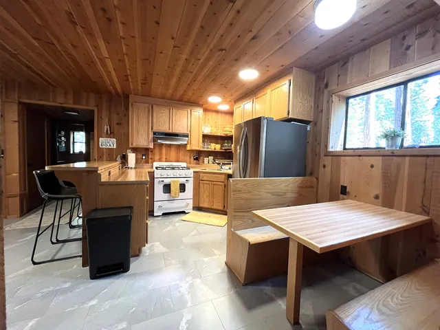 a kitchen with a table chairs refrigerator and cabinets