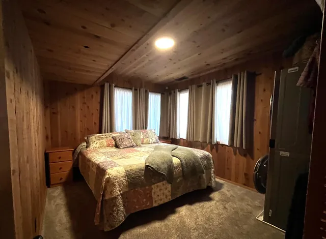 a bed sitting in a spacious bedroom next to a window