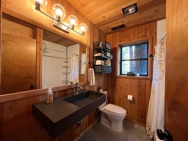 a bathroom with a sink a toilet and shower