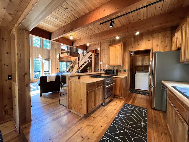 a kitchen with stainless steel appliances granite countertop a refrigerator a stove and a wooden floors