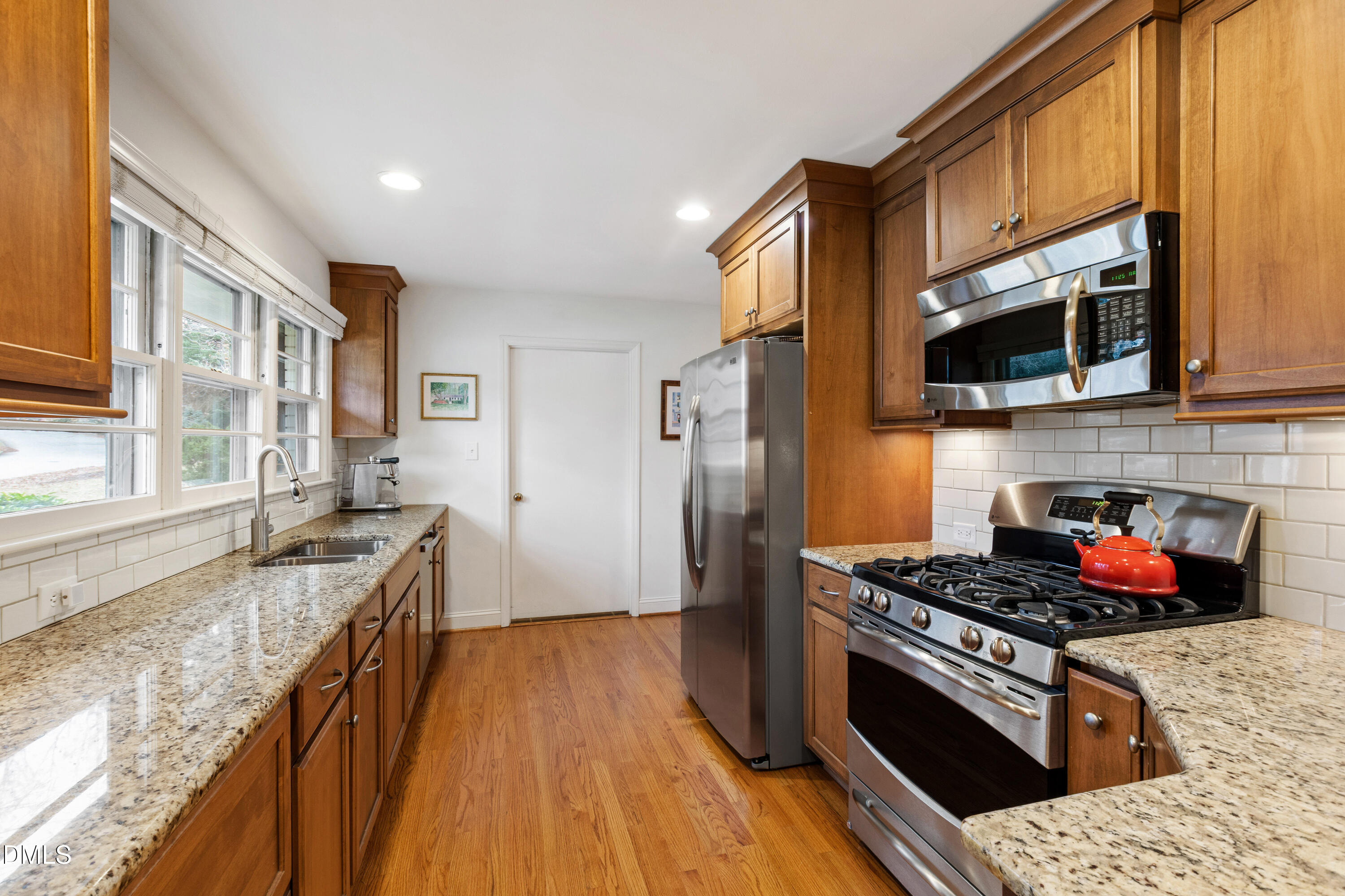 908 Brookwood Drive Raleigh, NC 27607 - Photo 8 of 27 a kitchen with stainless steel appliances granite countertop a stove a sink and a refrigerator