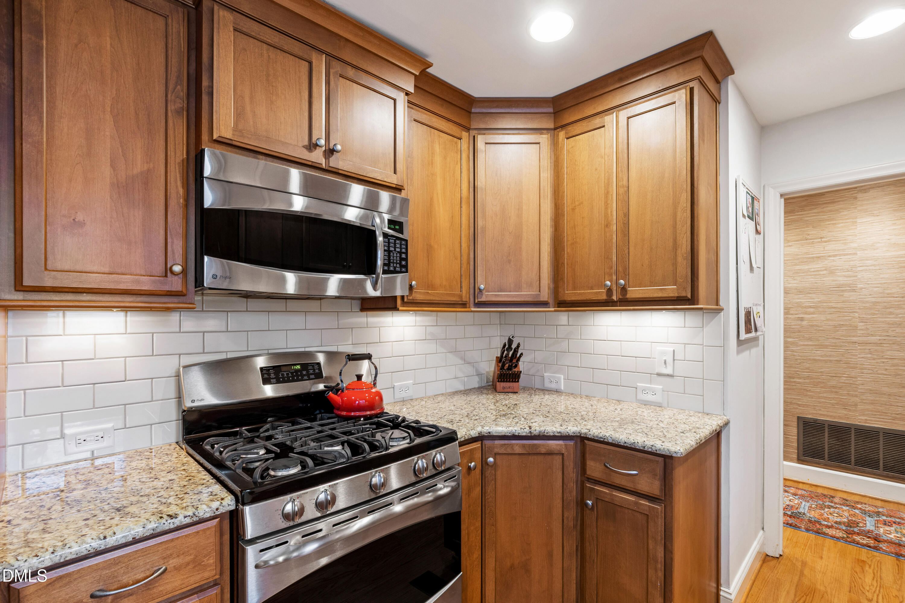 908 Brookwood Drive Raleigh, NC 27607 - Photo 10 of 27 a kitchen with stainless steel appliances granite countertop a stove and a microwave