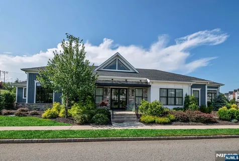 a front view of a house with a yard and potted plants