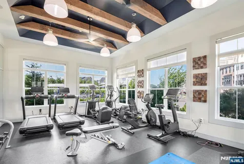 a living room with furniture gym and large windows