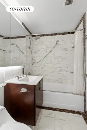 a bathroom with a granite countertop sink a mirror and shower