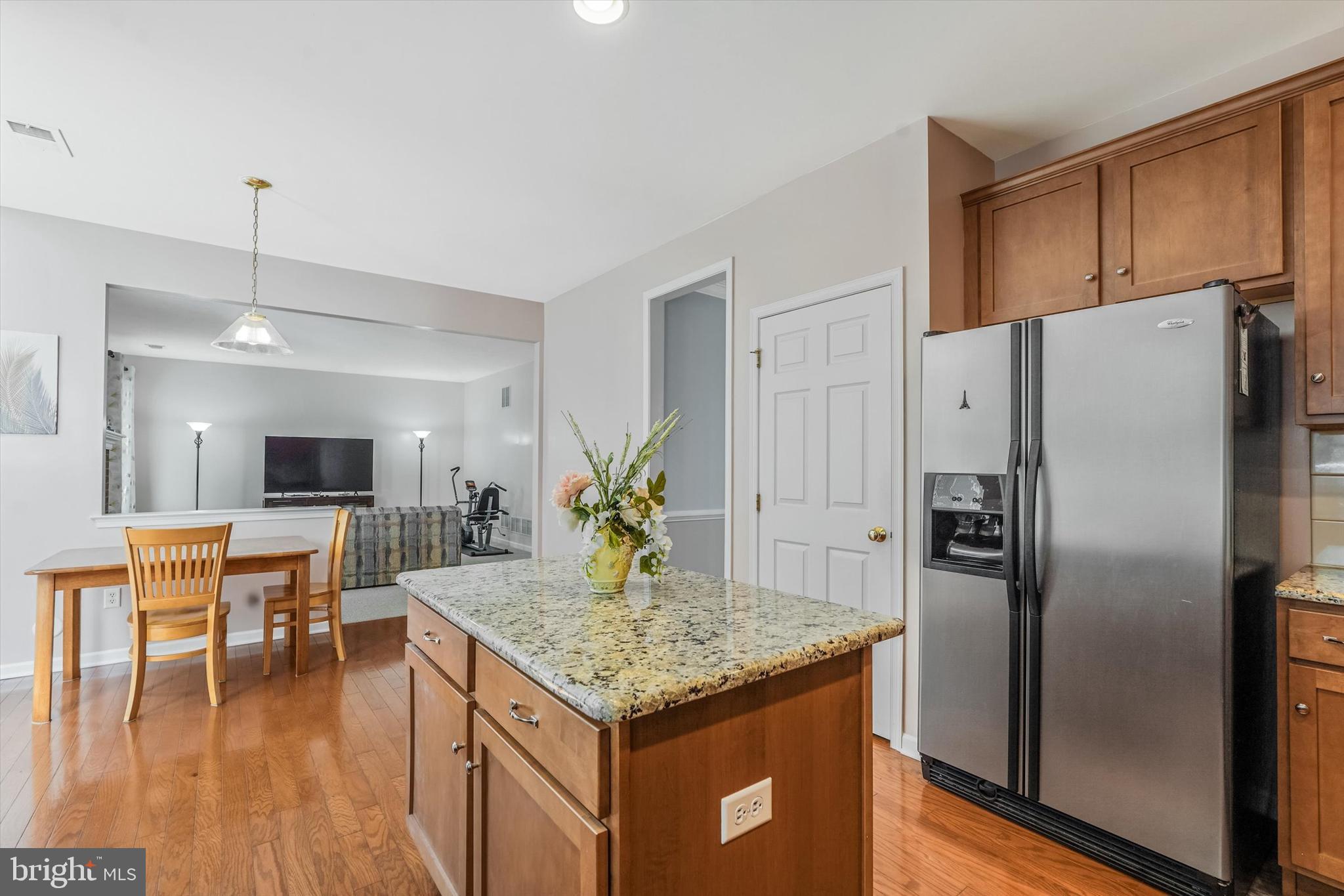 14 Devonshire Drive Princeton, NJ 08540 - Photo 14 of 36 a kitchen with granite countertop kitchen island stainless steel appliances a refrigerator a stove a dining table and chairs with wooden floor