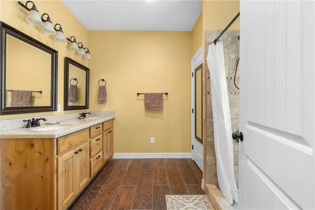 a bathroom with a double vanity sink a mirror and a shower