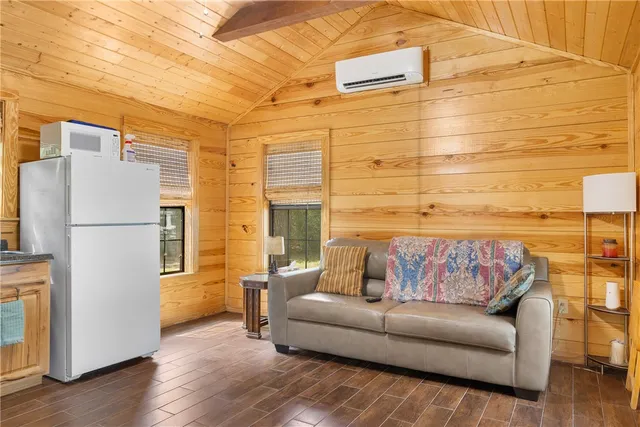 a living room with furniture and a refrigerator