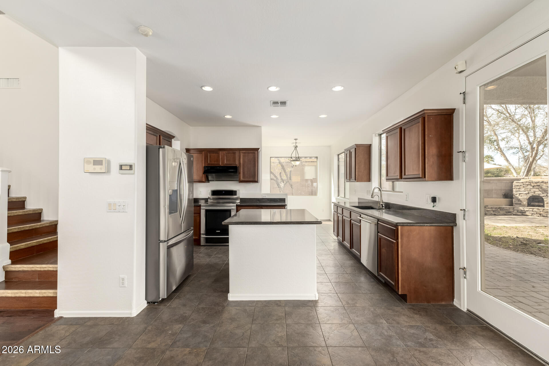 3628 East Janelle Way Gilbert, AZ 85298 - Photo 11 of 38 a kitchen with stainless steel appliances a stove top oven a sink a refrigerator and white cabinets