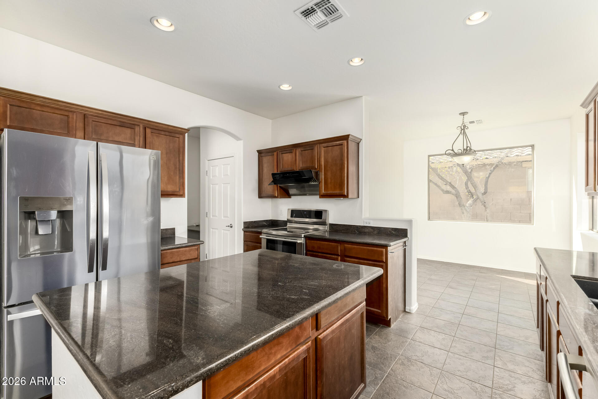 3628 East Janelle Way Gilbert, AZ 85298 - Photo 14 of 38 a kitchen with stainless steel appliances granite countertop a refrigerator a stove and a sink with wooden floor