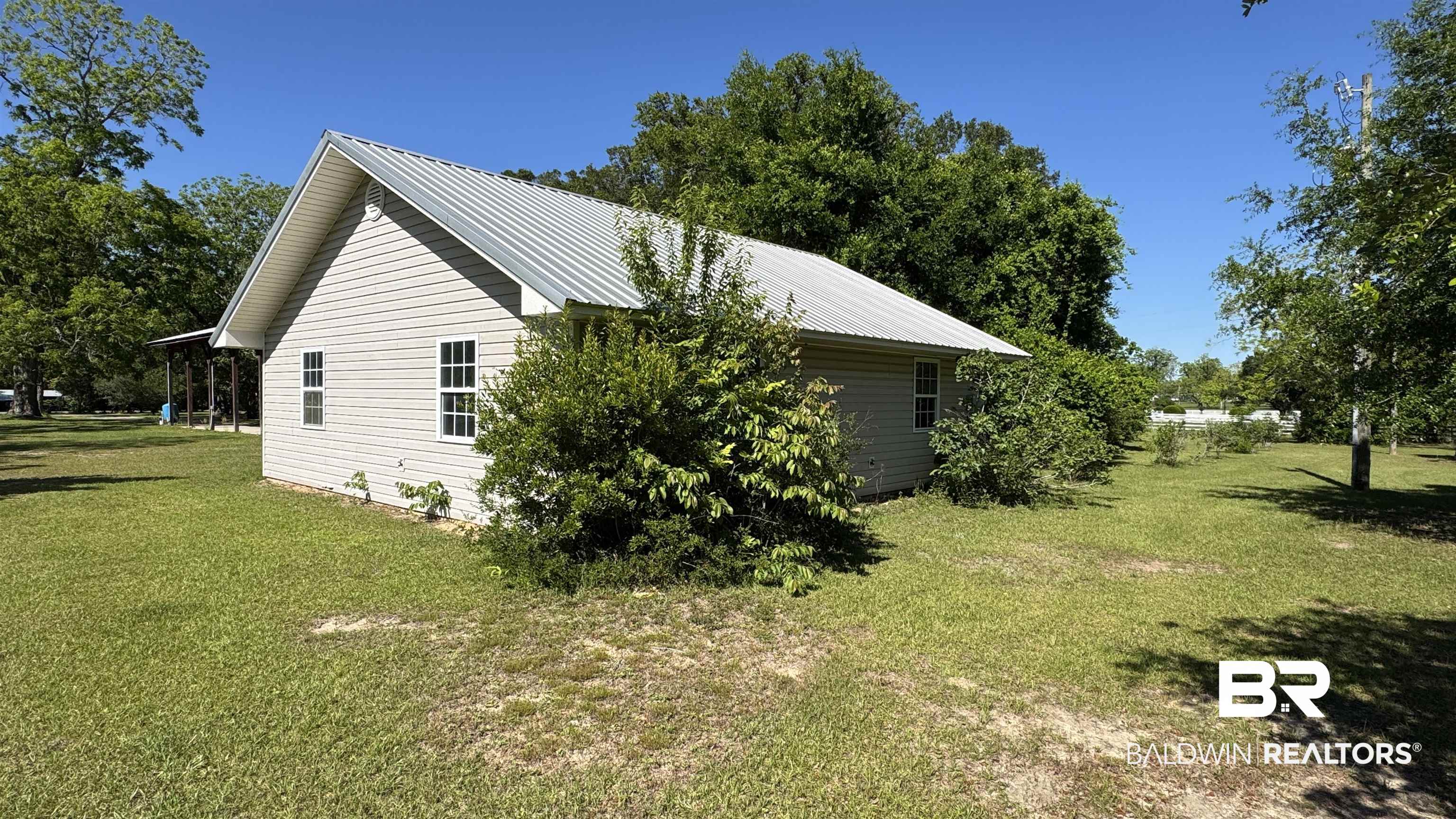 33370 Highway 98 Lillian, AL 36549 - Photo 15 of 58 Single-story residence featuring light-colored siding and a metal roof