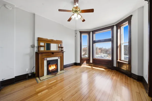 a view of an empty room with a fireplace and a window