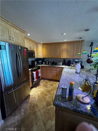 a kitchen with stainless steel appliances granite countertop a refrigerator and a stove