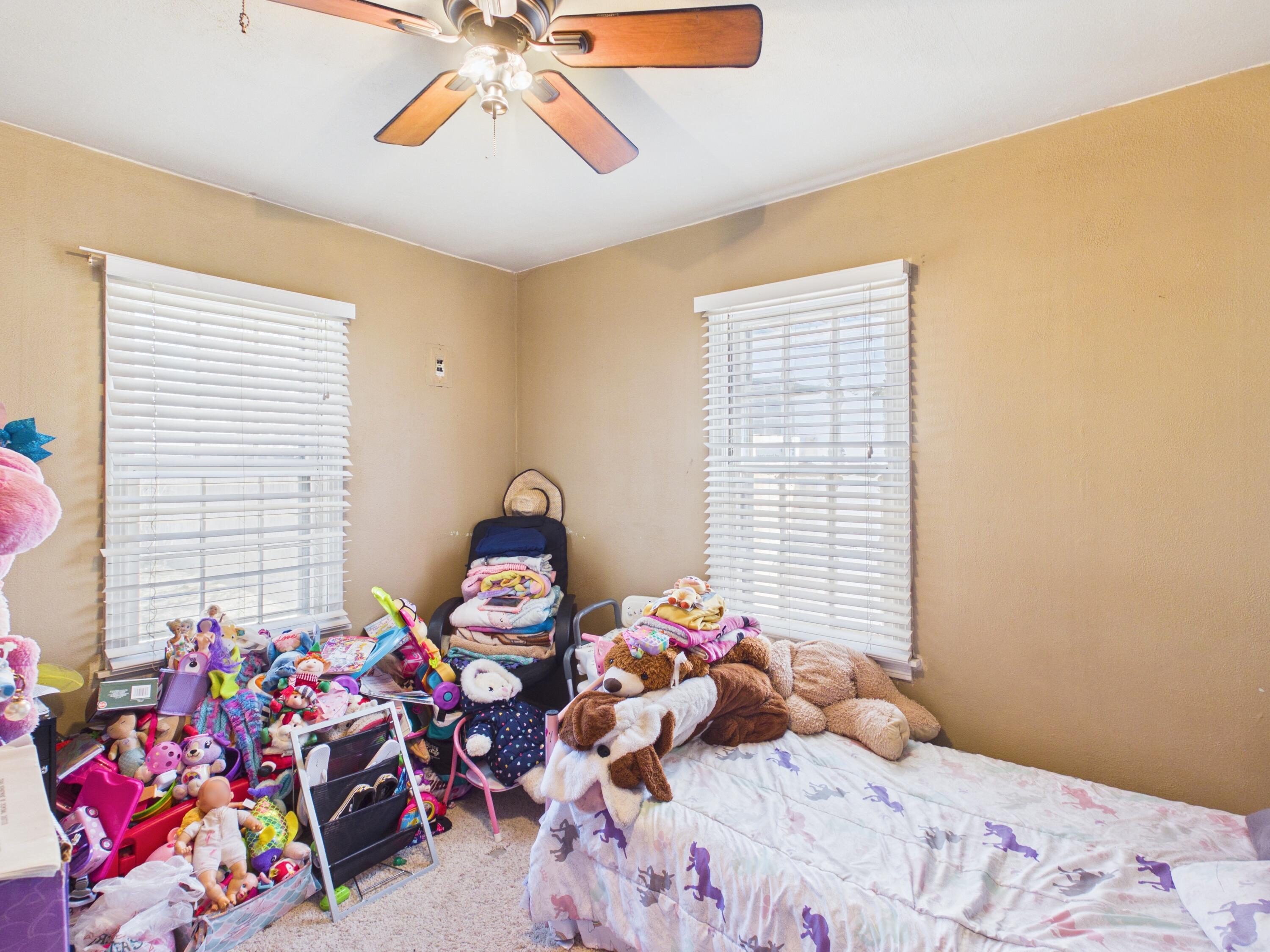 2016 41st Street Lubbock, TX 79412 - Photo 12 of 22 a bedroom with a bed purple white bedspread and pillows