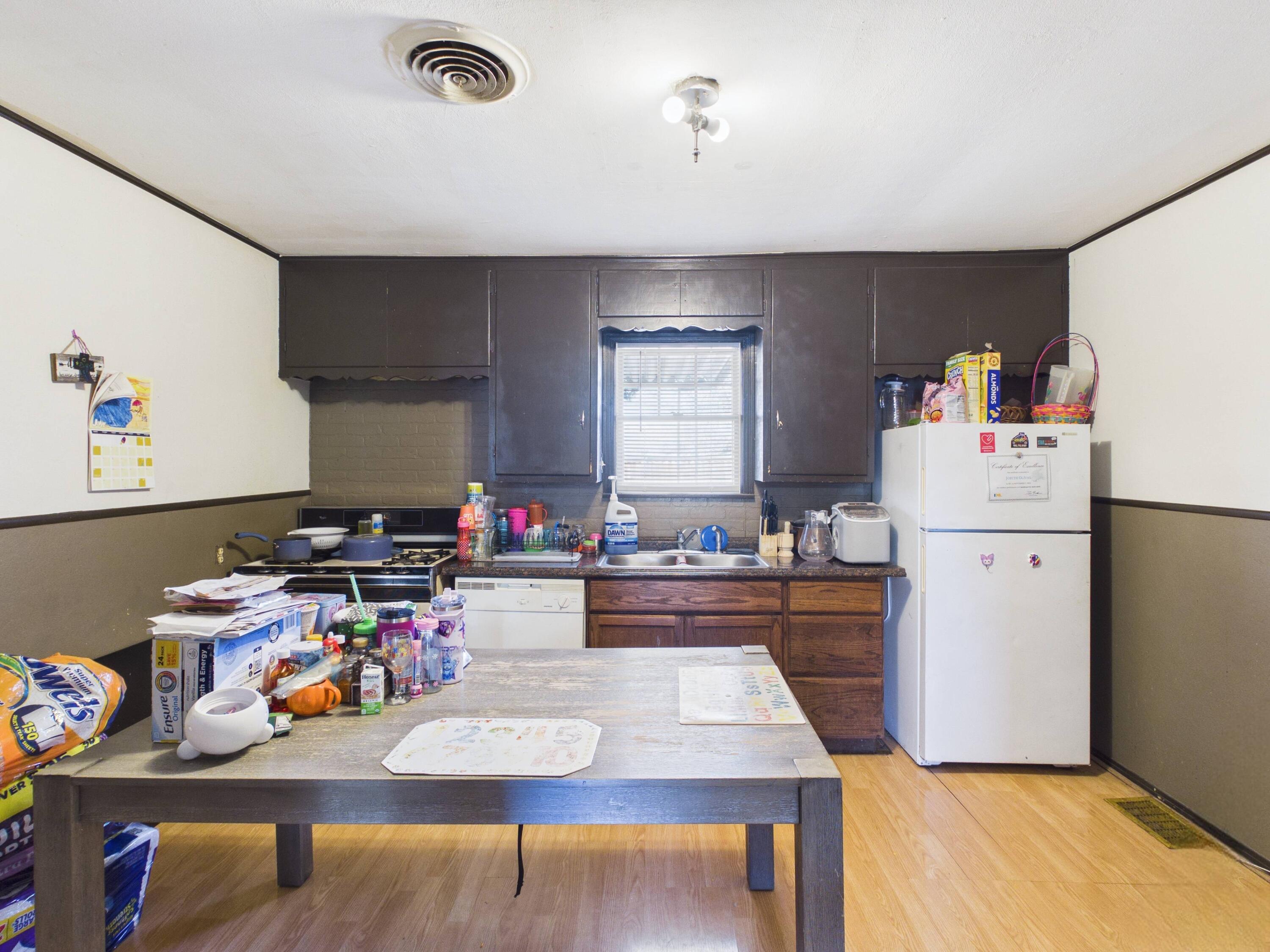 2016 41st Street Lubbock, TX 79412 - Photo 7 of 22 a kitchen with a refrigerator a stove and wooden floor