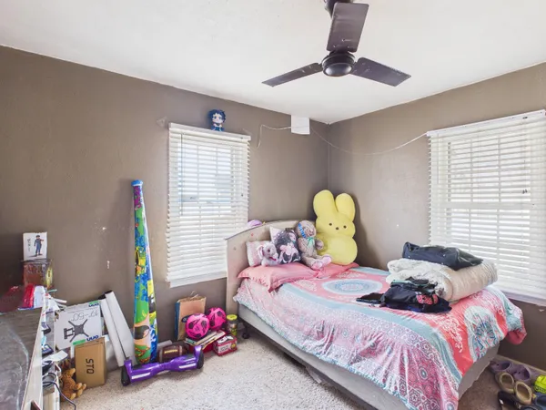 a bedroom with a bed and teddy bear on bed
