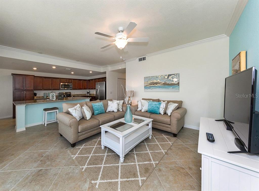 16904 Vardon Terrace, Unit 202 Lakewood Ranch, FL 34211 - Photo 19 of 30 a living room with furniture and a flat screen tv
