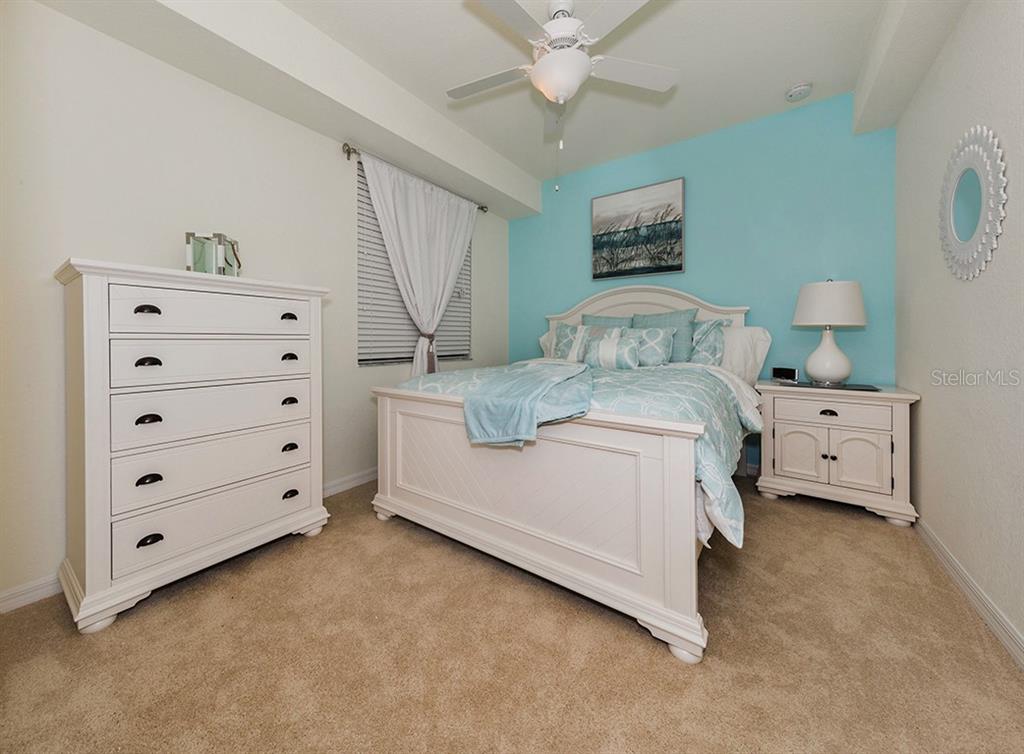 16904 Vardon Terrace, Unit 202 Lakewood Ranch, FL 34211 - Photo 25 of 30 a room with a bed and a dresser in it