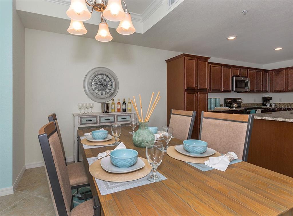 16904 Vardon Terrace, Unit 202 Lakewood Ranch, FL 34211 - Photo 8 of 30 a kitchen with a dining table and chairs