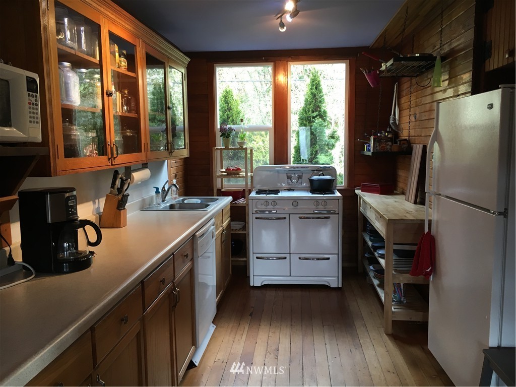 8725 Southwest Cemetery Road Vashon, WA 98070 - Photo 2 of 14 a kitchen with a refrigerator and a sink