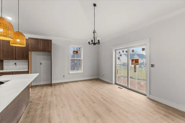 a view of a room with wooden floor and a ceiling fan