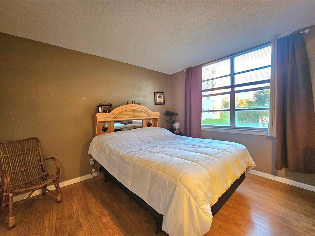 1460 Northwest 80th Avenue, Unit 101 Margate, FL 33063 - Photo 12 of 27 a bedroom with a bed and window