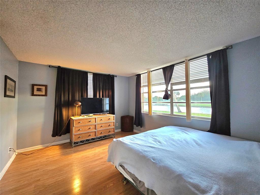 1460 Northwest 80th Avenue, Unit 101 Margate, FL 33063 - Photo 14 of 27 a spacious bedroom with a large bed and a dresser