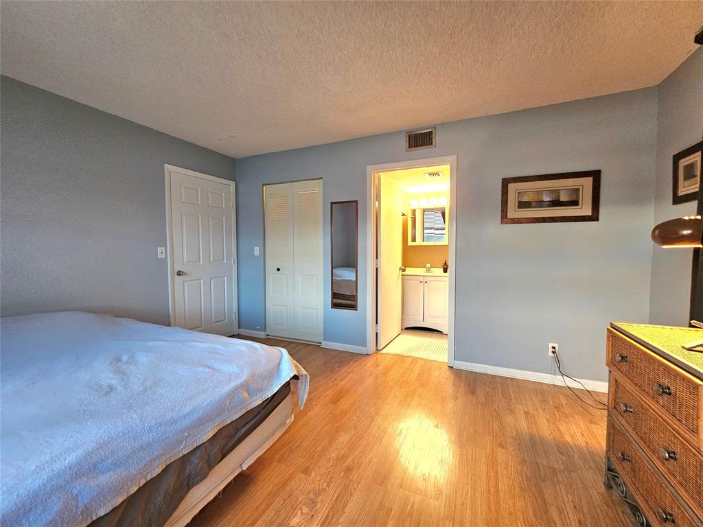 1460 Northwest 80th Avenue, Unit 101 Margate, FL 33063 - Photo 15 of 27 a bedroom with a bed and wooden floor