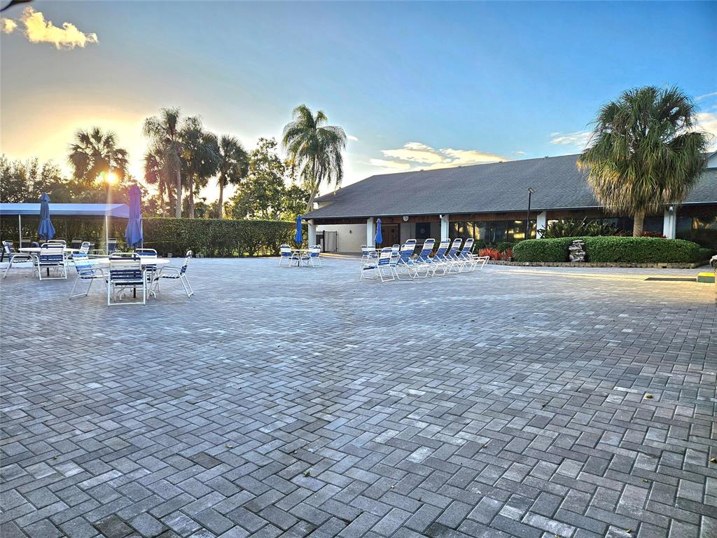 1460 Northwest 80th Avenue, Unit 101 Margate, FL 33063 - Photo 23 of 27 a view of a patio with a table and chairs under an umbrella