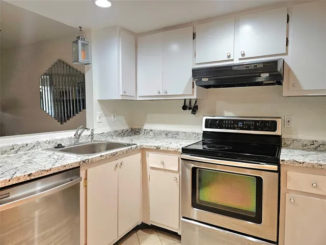 a kitchen with granite countertop cabinets stainless steel appliances and sink