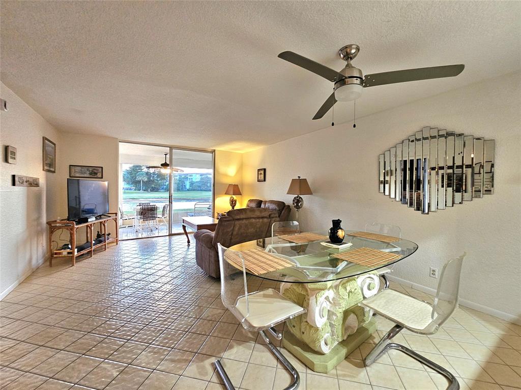 1460 Northwest 80th Avenue, Unit 101 Margate, FL 33063 - Photo 9 of 27 a dining room with furniture and a floor to ceiling window